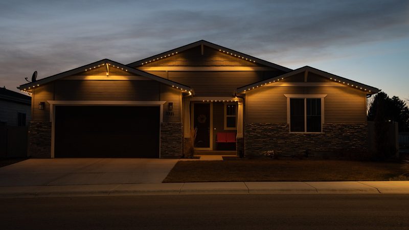A home and garage lit in warm white