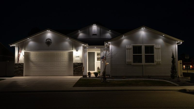 A two-story home front lit in warm white